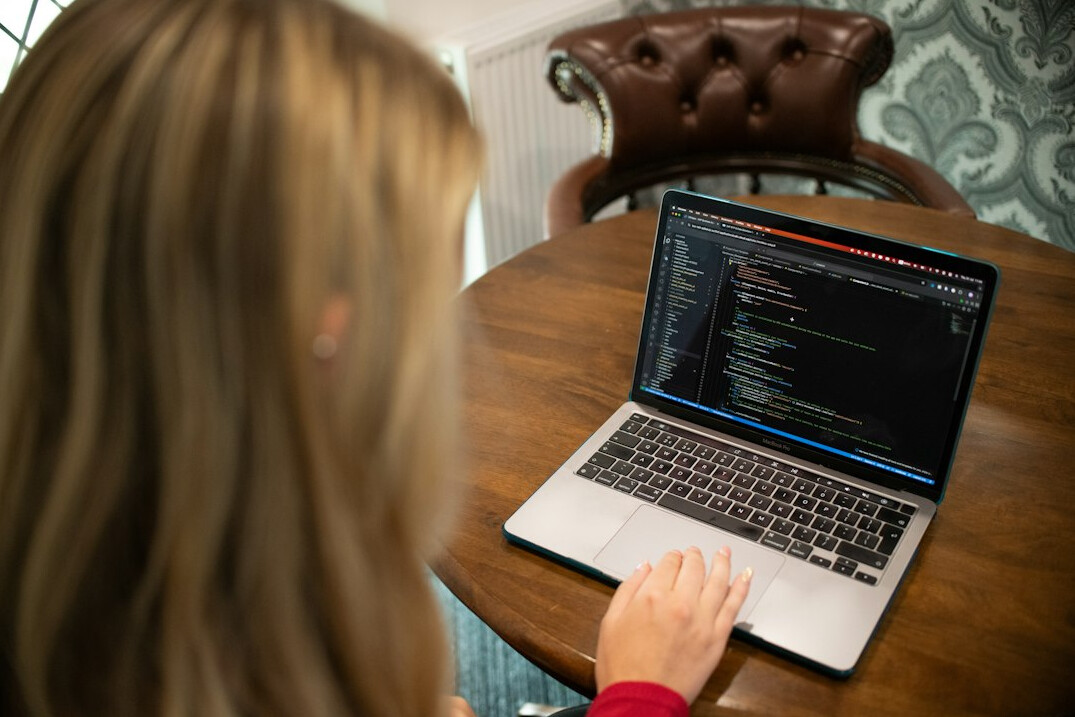 young person coding on laptop